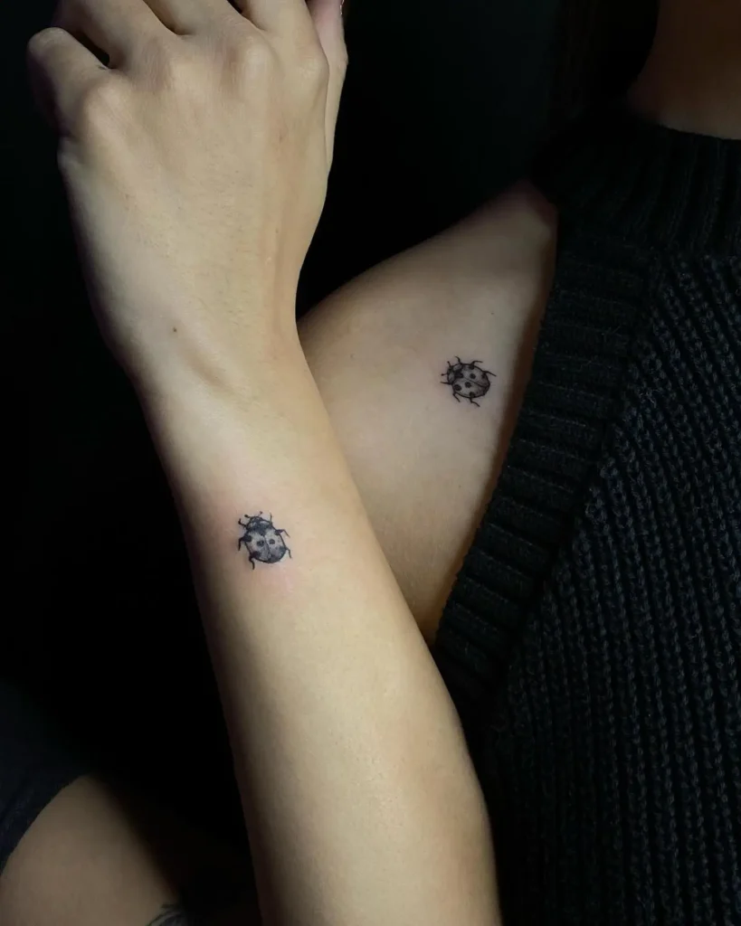 Matching small ladybug tattoos for women on the wrist and shoulder—minimalist, detailed body art symbolizing luck and friendship.
