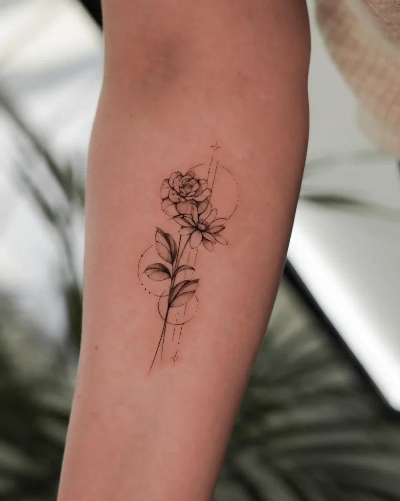 Fineline floral tattoo with roses, daisies, and star accents on forearm, combining nature and celestial themes to symbolize love, growth, and cherished memories.