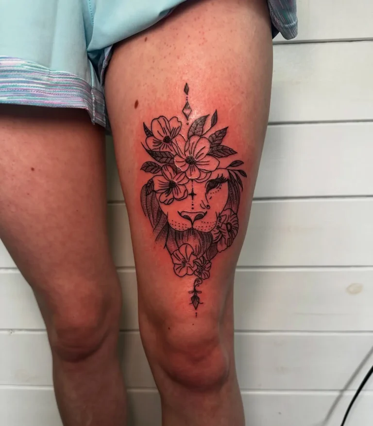 Lion thigh tattoo with floral crown and ornamental design, placed on the upper leg. Fine black ink with bold shading and petal detailing. Strong yet peaceful look, fitting for animal tattoo ideas arm, thigh, or sleeve style. Beautiful mix of nature and strength in a minimalist, vertical layout.








