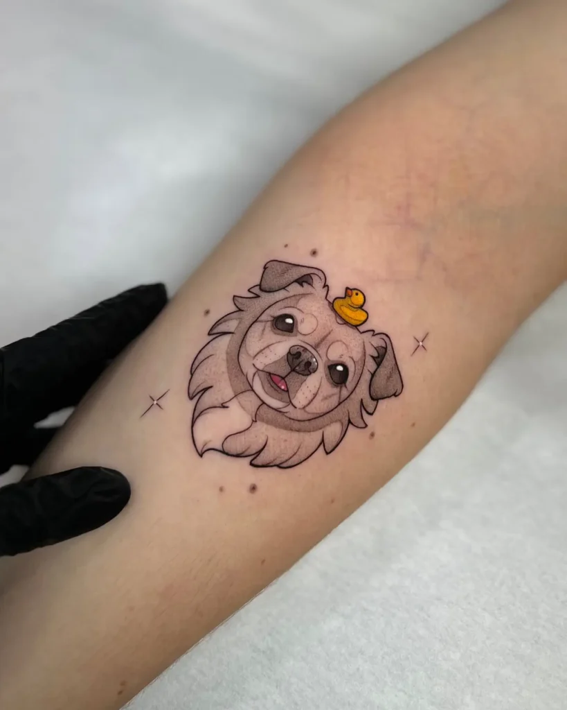 Cartoon dog portrait tattoo with a small yellow rubber duck on its head, playful dog tattoo design on arm