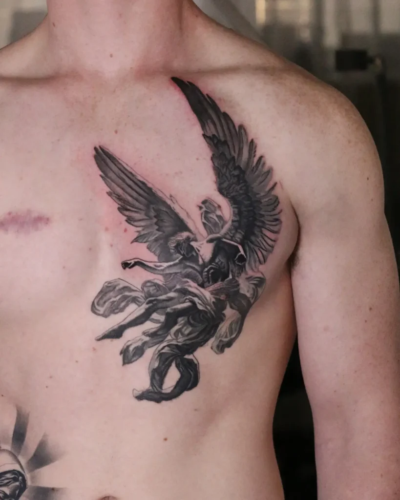 Black and grey chest tattoo for men depicting a winged angel lifting a figure skyward; detailed shading and dynamic composition symbolize redemption, strength, and spiritual guidance on the upper chest.