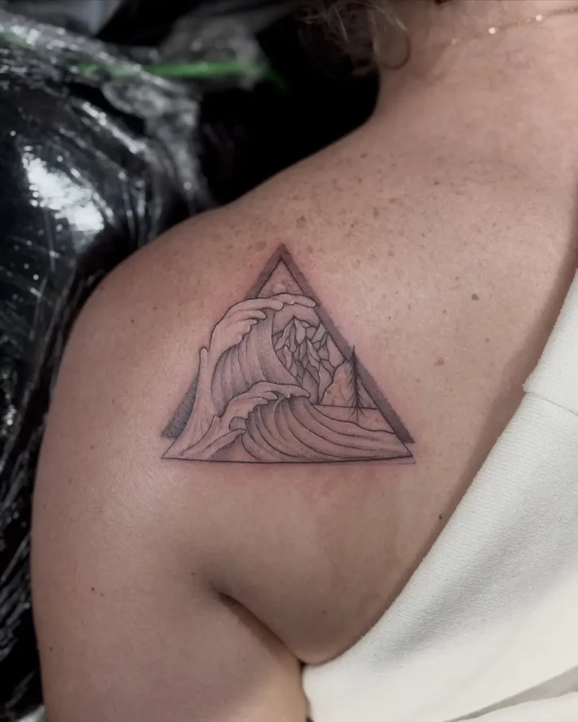 Fine line geometric tattoo of ocean waves and mountains inside a triangle on upper back, symbolizing nature and balance.