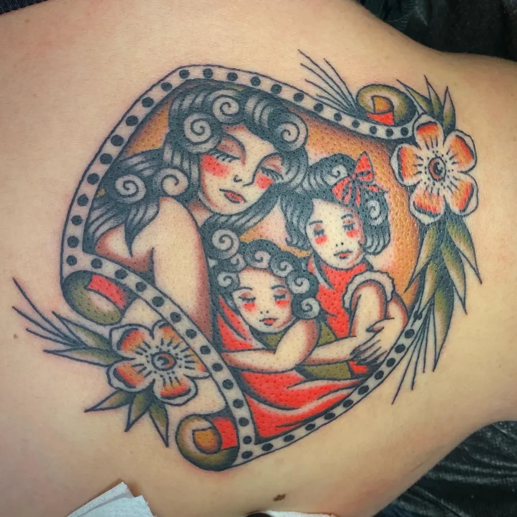 Alt Text:
Colorful vintage tattoo features a mother embracing two daughters, framed by decorative flowers and curved lines. Their faces are shaded with red and orange, and each figure has curly hair. The traditional style and warm colors create a nostalgic look, making this tattoo a special choice for mom and daughter tattoos unique, symbolizing family love and cherished moments.