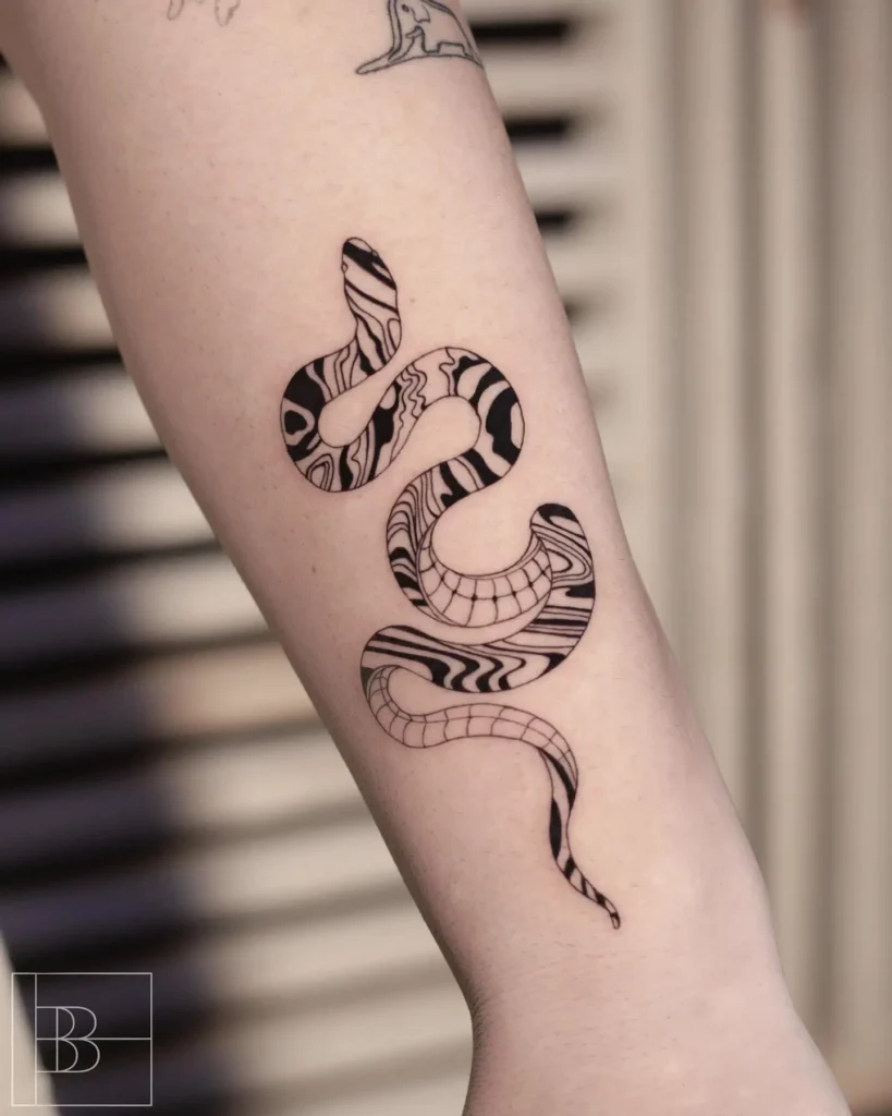 Abstract snake tattoo on inner forearm with bold black ink and intricate patterned design, blending geometric and psychedelic linework.

