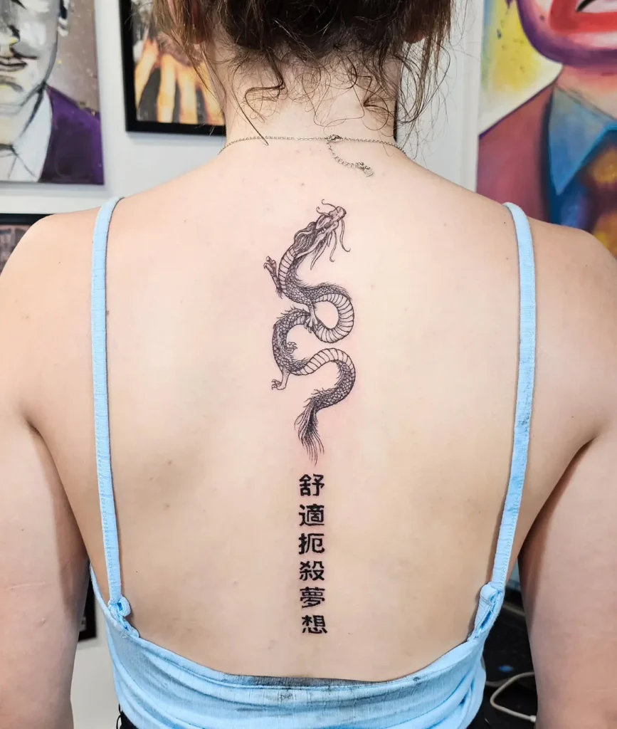 A minimalist dotwork spine tattoo featuring fine geometric lines and tiny detailed elements running vertically down a woman’s back.