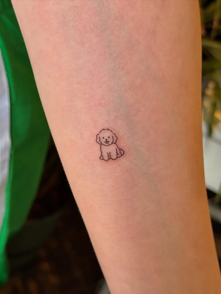 Small minimalist tattoo of a happy dog outlined with fine lines, placed on the forearm, perfect for subtle dog tattoo ideas minimalist.