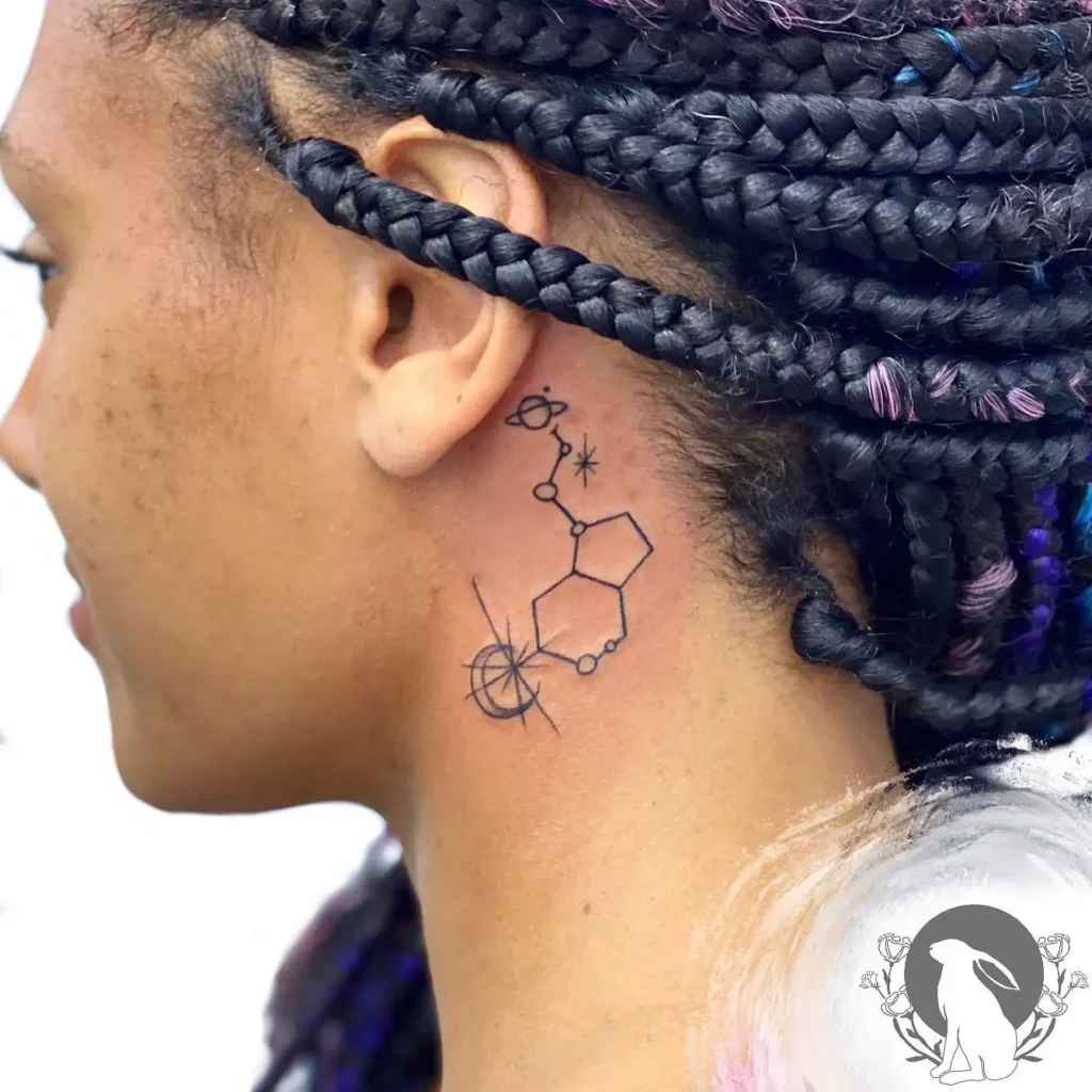 A behind the ear tattoo of a serotonin molecule integrated with planets, stars, and spark elements, inked in fine black lines on a woman with braided hair featuring subtle purple highlights.









