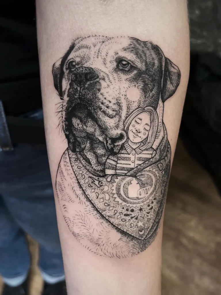 Black and gray tattoo of a large dog wearing a patterned bandana, with a minimal line drawing of a smiling person resting against the dog’s neck, symbolizing a strong bond and remembrance.