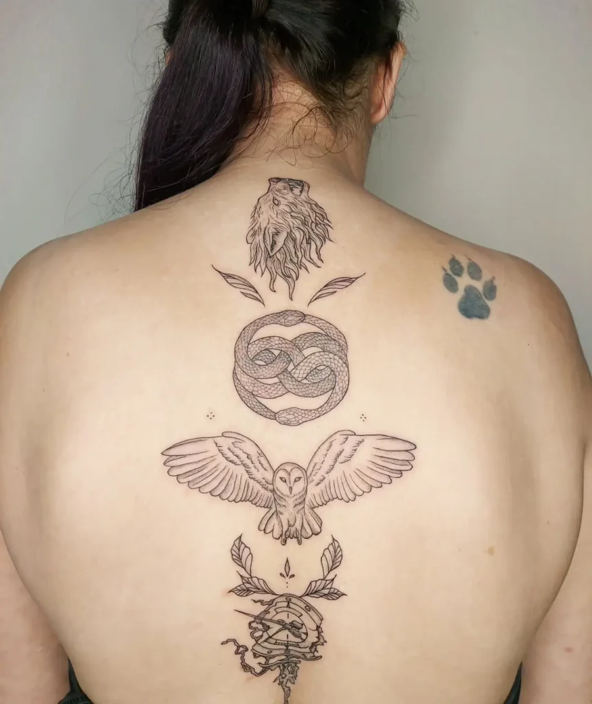 A spine tattoo with a fine-line fern stem, small stars, and dotted accents running down a woman’s back