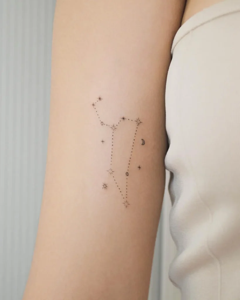 Minimal fine line tattoo of a star constellation with dotted lines, tiny stars, and a crescent moon on the upper arm, symbolizing dreams and personal meaning.









