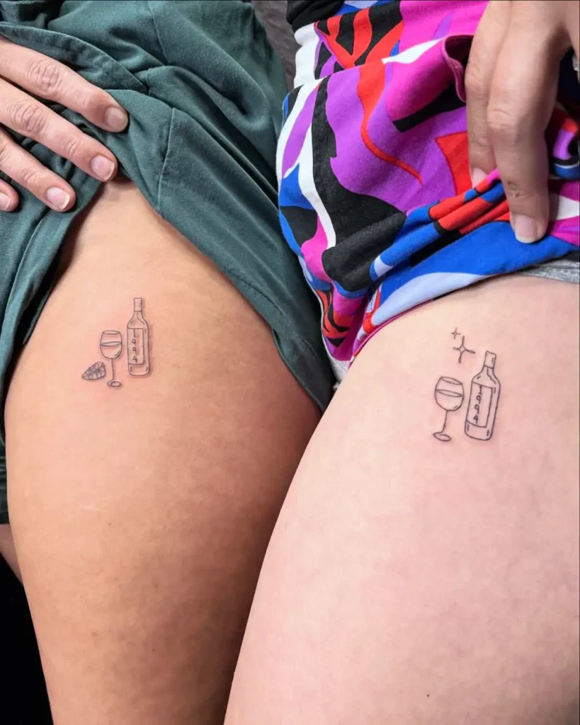 Matching fine line tattoos of wine bottle, glass, and cheese wedge with the year 1994, symbolizing friendship and celebration.