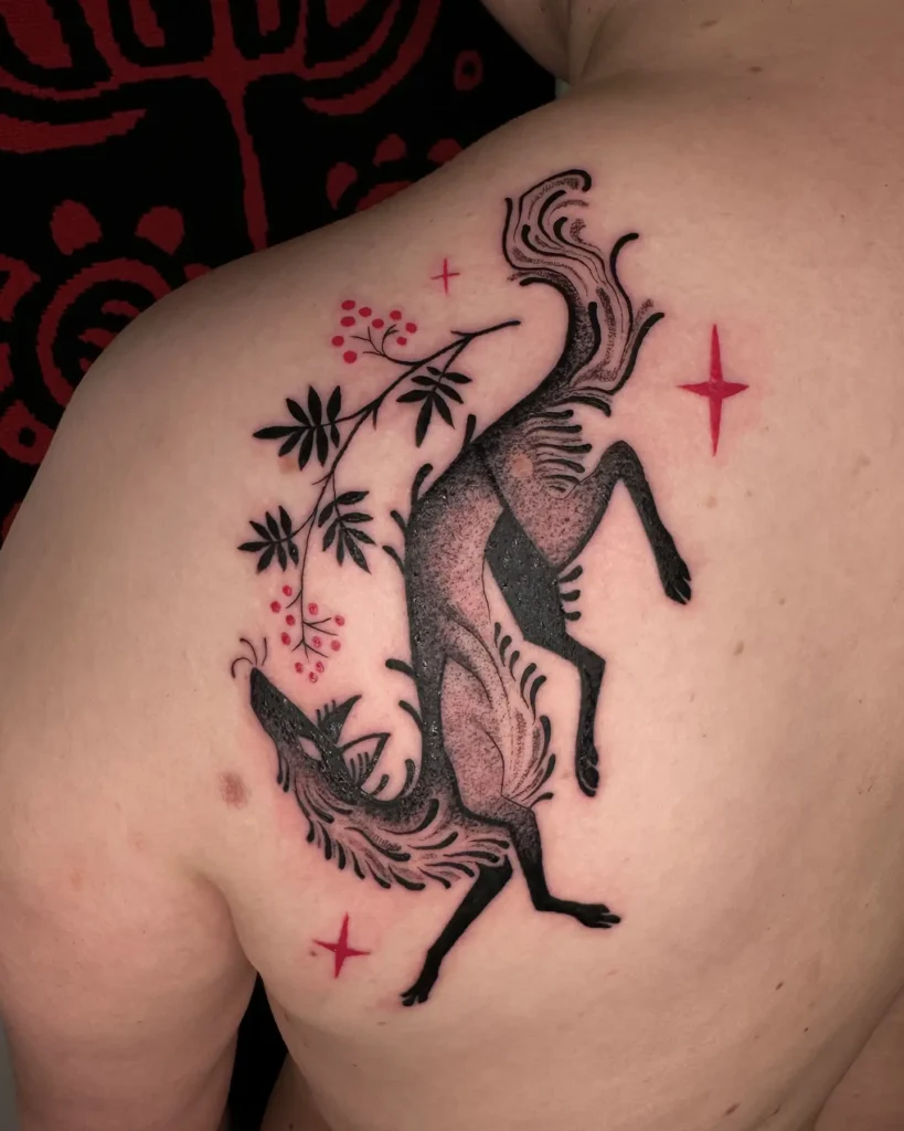 Tattoo of a leaping fox with stylized black fur, dotwork texture, and flowing tail. Decorated with botanical elements and red stars on the upper back. Features modern folk art style with strong contrast and natural rhythm. A standout design for animal tattoo ideas simple but rich in symbolism. Ideal for shoulder or back placement.








