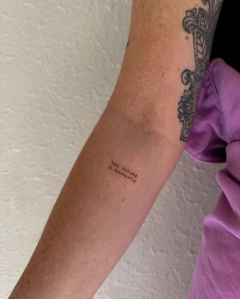 10. "The Future Is Romantic" Tiny Text Tattoo