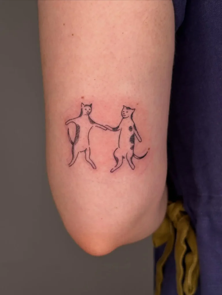 11. Dancing Cats Handshake Tattoo