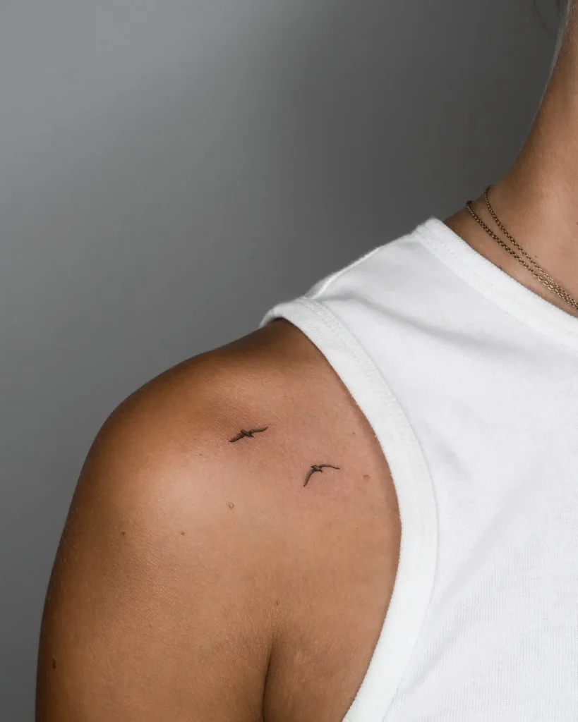 12. Minimalist Flying Birds Shoulder Tattoo