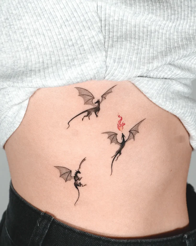12. Tiny Dragons Rib Tattoo