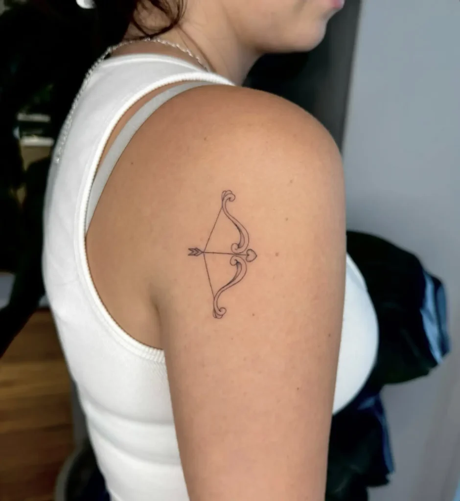 14. Elegant Bow and Heart Arrow Shoulder Tattoo