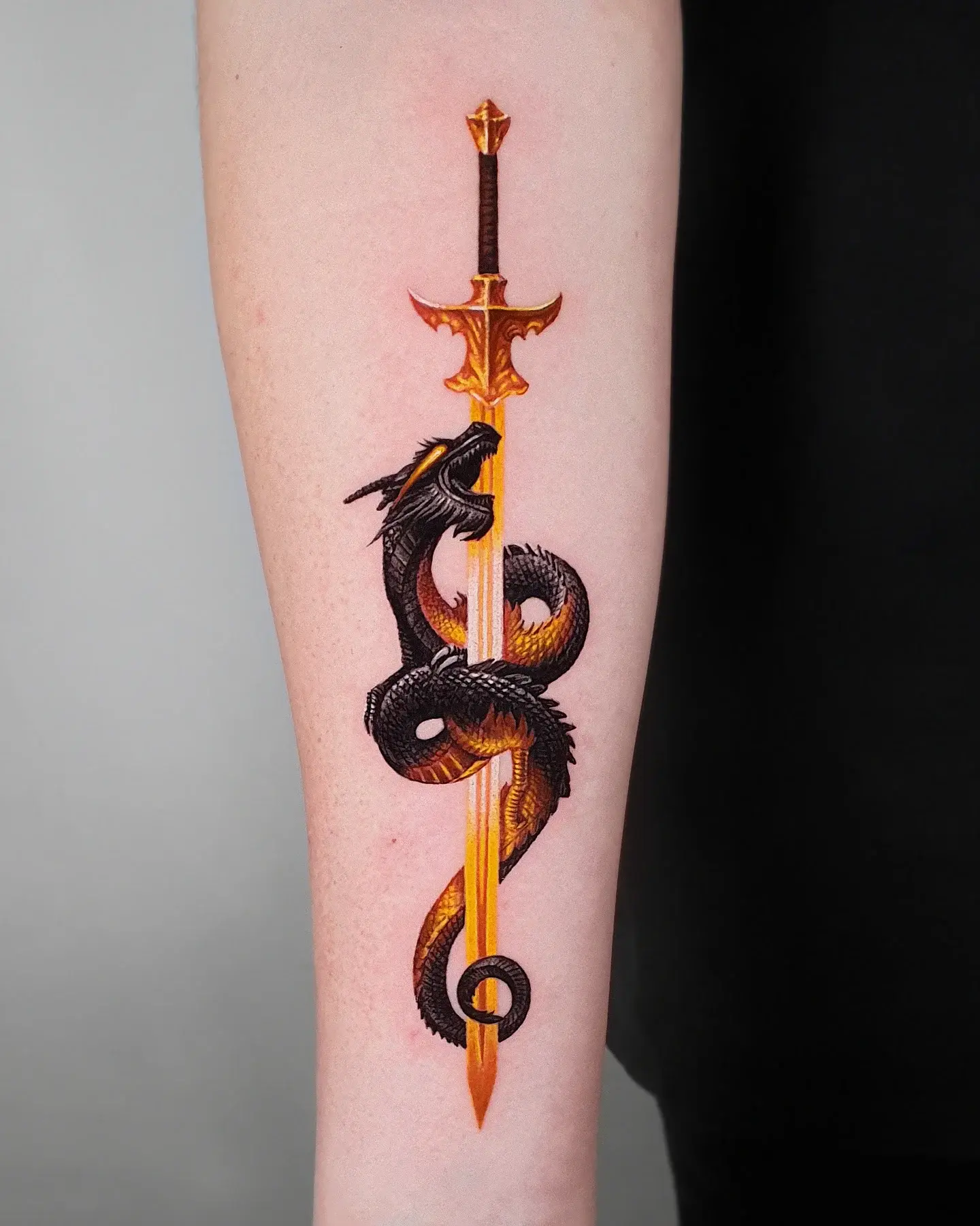 5. Sword and Dragon Forearm Tattoo