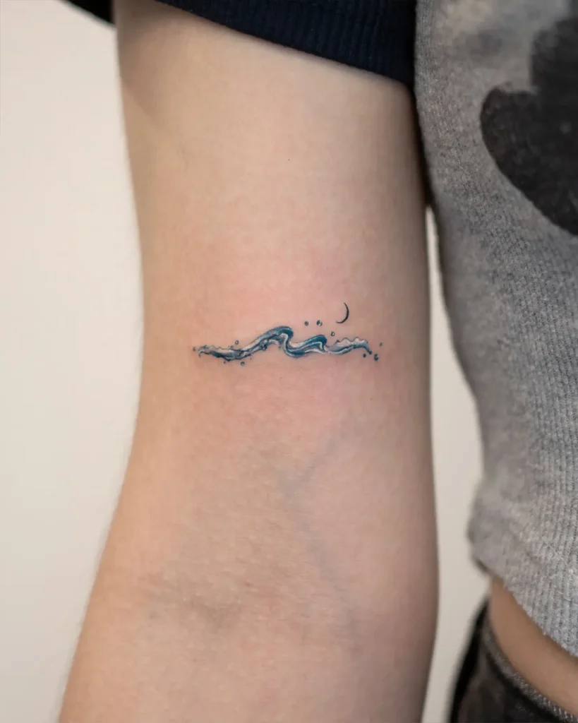 7. Ocean Wave and Crescent Tiny Tattoo