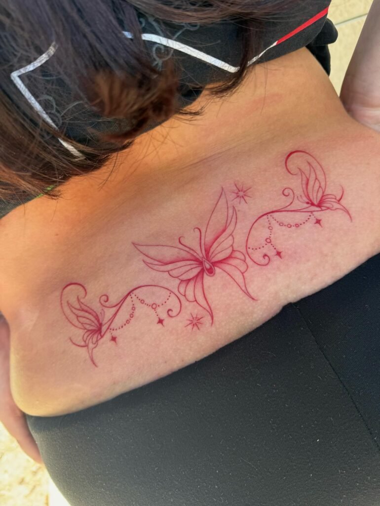 18. Butterfly Trio Red Ink Lower Back Tattoo