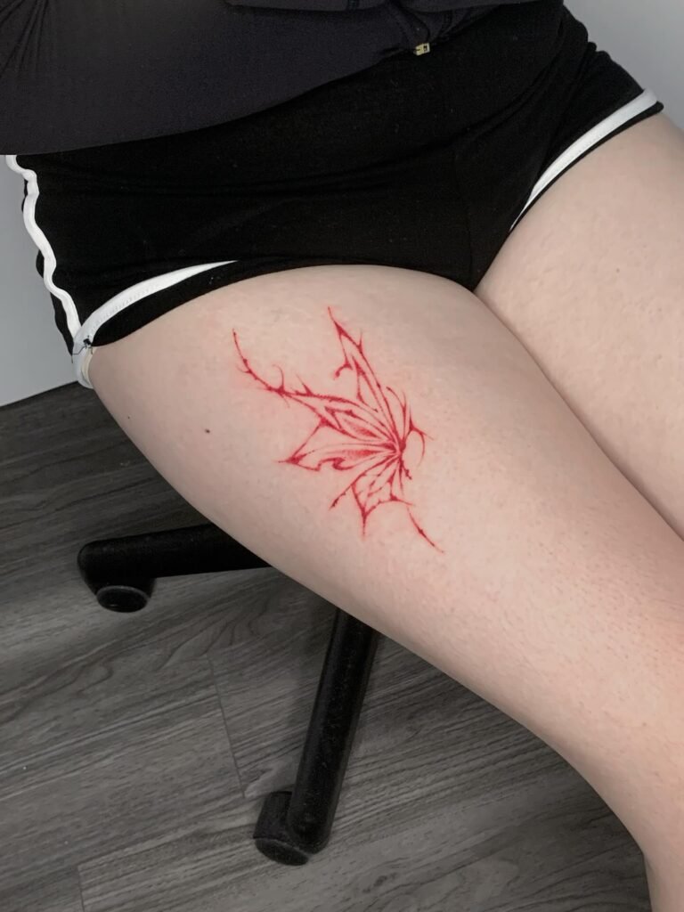 24. Abstract Red Maple Leaf Tattoo on Thigh